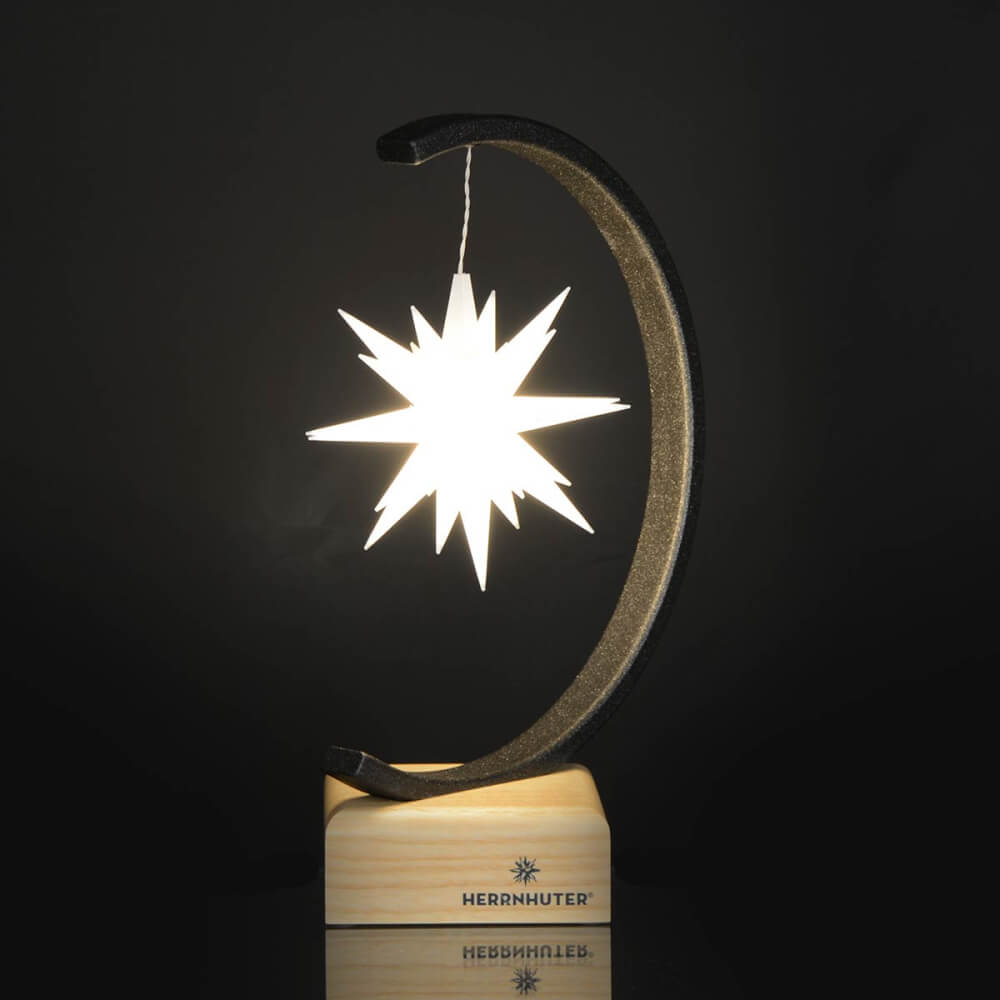 Bright shining white plastic star hanging on herrnhuter star bow