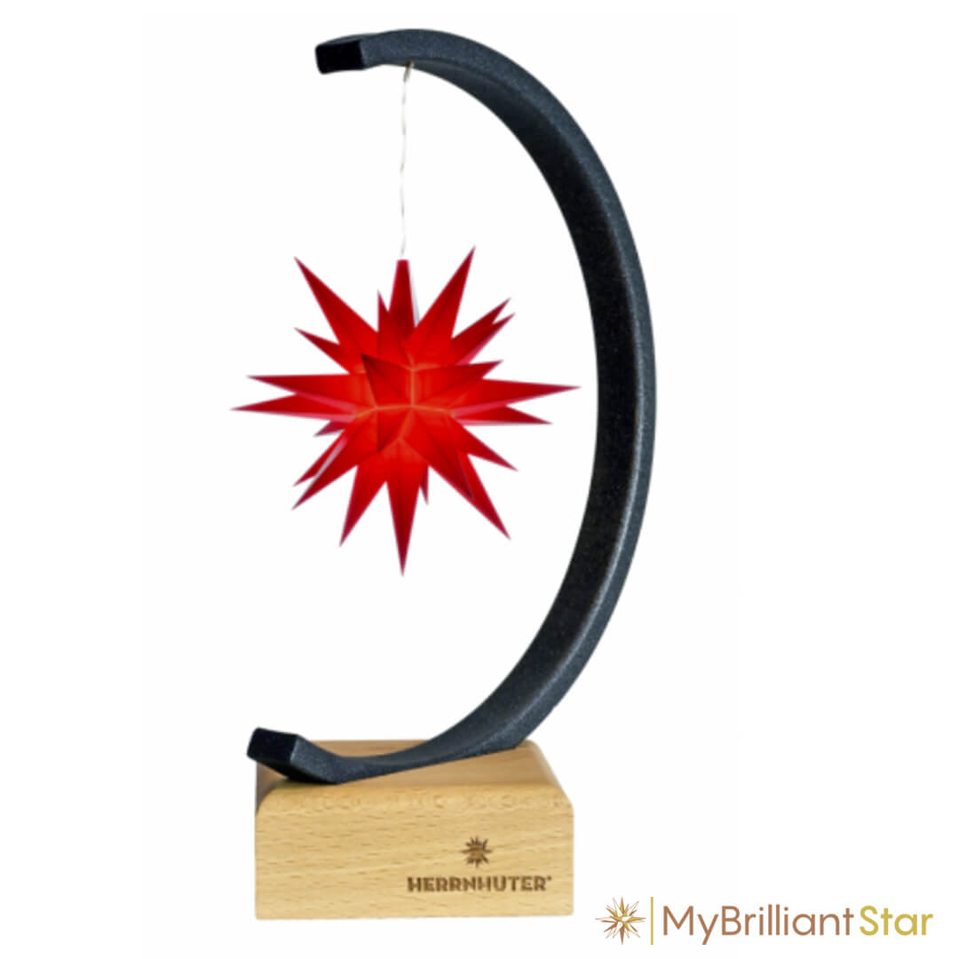 Shining red plastic star from Herrnhuter, hanging on star bow