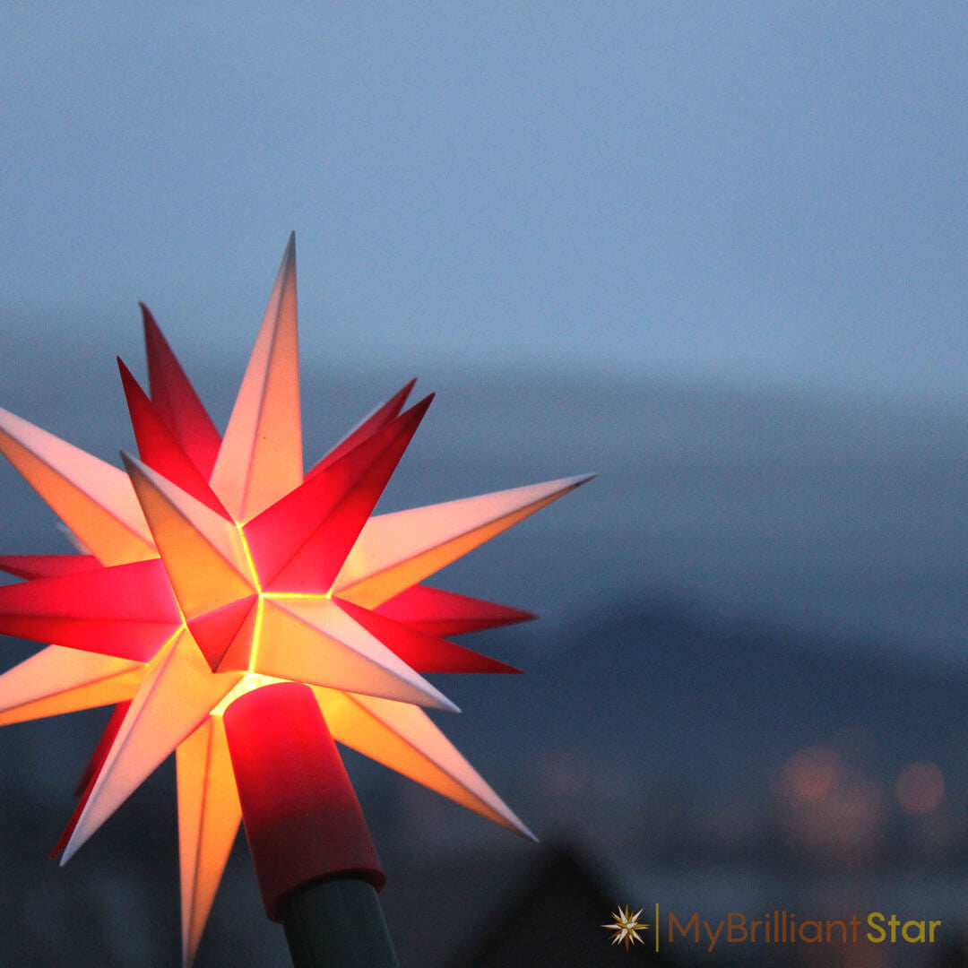 Original Herrnhut plastic star chain, white / red, ~ 12 m / 470 inch length i front of blue background