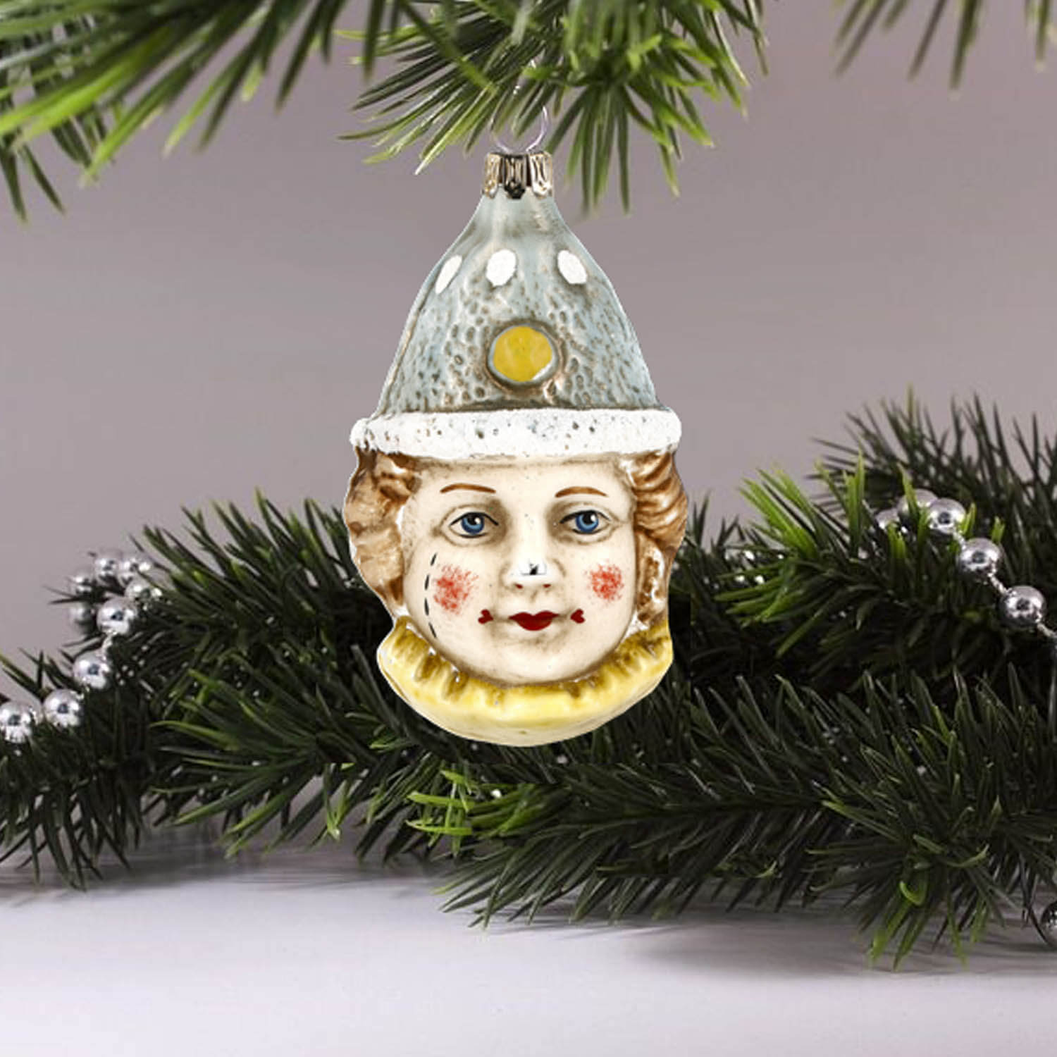 MAROLIN® - Glass ornament "Clown with blue hat" hanging on green Christmas tree