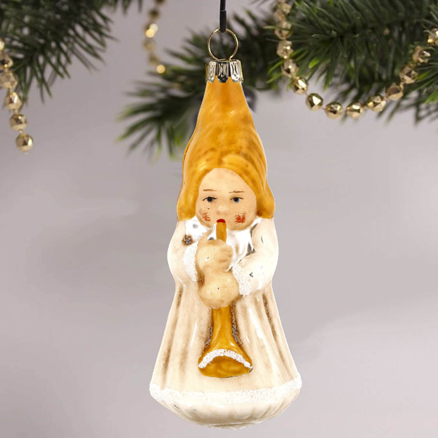 MAROLIN® - Glass ornament "Trumpeting angel" hanging on decorated Christmas tree