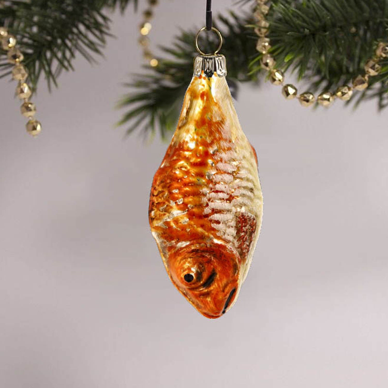 MAROLIN® - Miniature glass ornament "Fish orange" hanging on a decorated Christmas tree