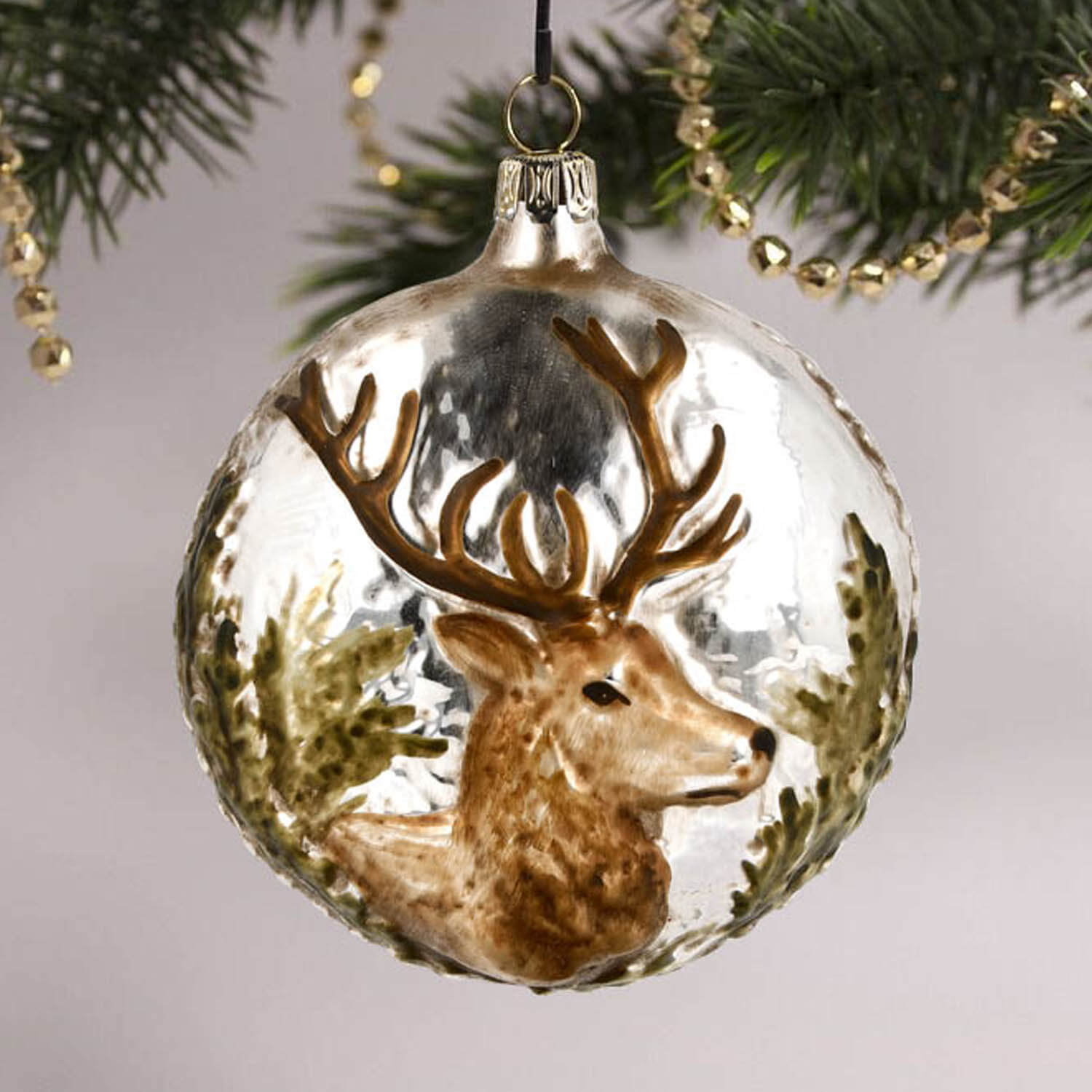 MAROLIN® - Glass ornament "Stag" haging in a decorated Christmas tree