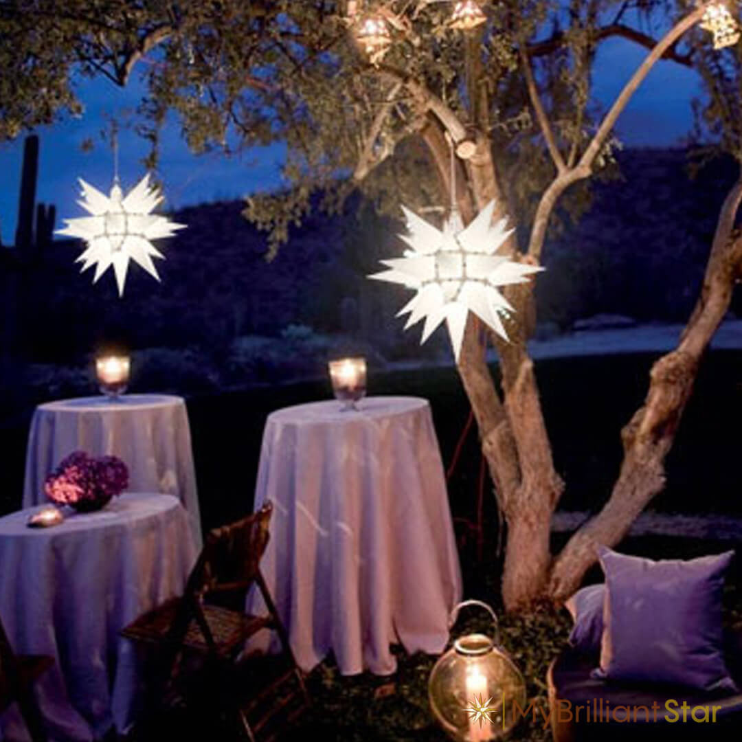 Original Herrnhut paper star, white, ~ 40 cm / 16 inch ø hanging in a tree