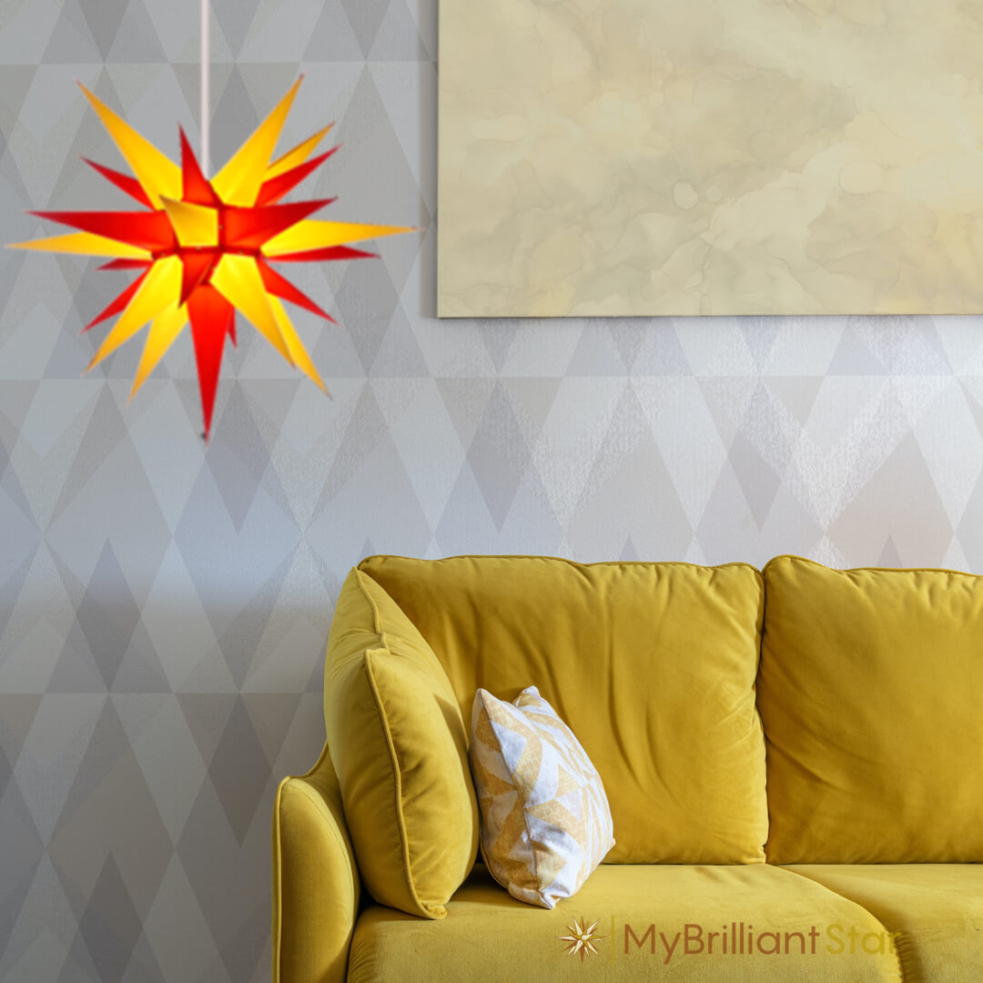 Original Herrnhut paper star, yellow / red, ~ 60 cm / 24 inch ø adding light to a living room with yellow couch