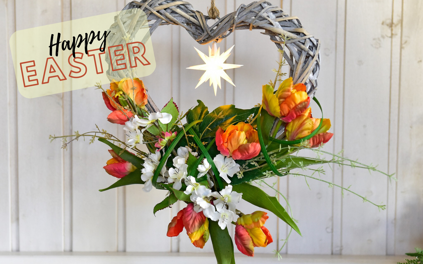 Happy Easter - Heart with tulips decorated hanging on a white wall
