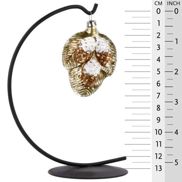 Charming vintage glass ornament with twigs and pine cones hanging on a star bow.