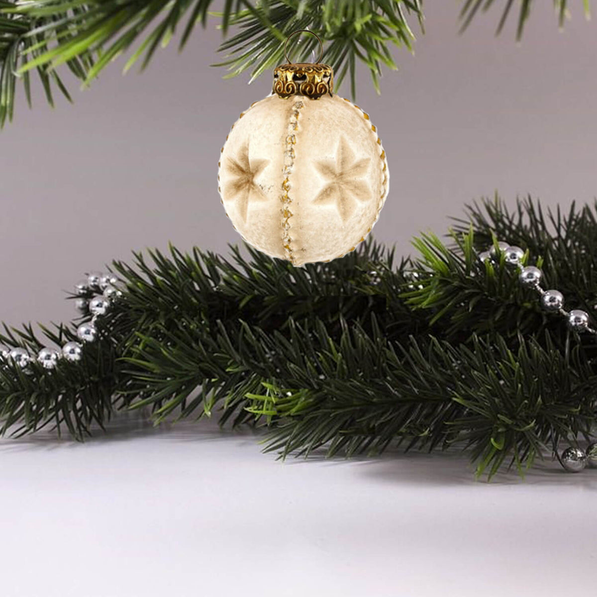 MAROLIN® - Paper-mâché &quot;Star&quot; vintage ornament positioned on a christmas tree highlighting its unique design and rustic charm.