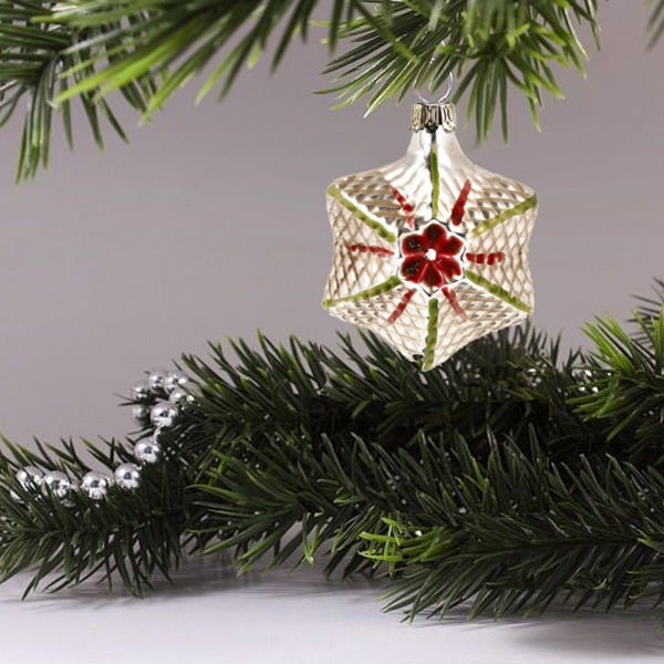 Decorative glass star ornament hanging on a Christmas tree, showcasing beautiful craftsmanship and a whimsical design.