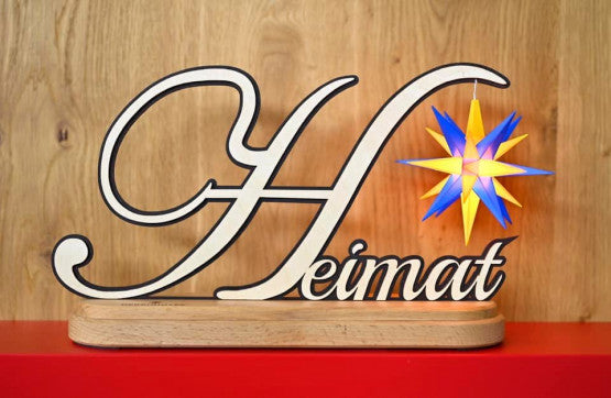 a sign: Heimat with blue and yellow plastic star