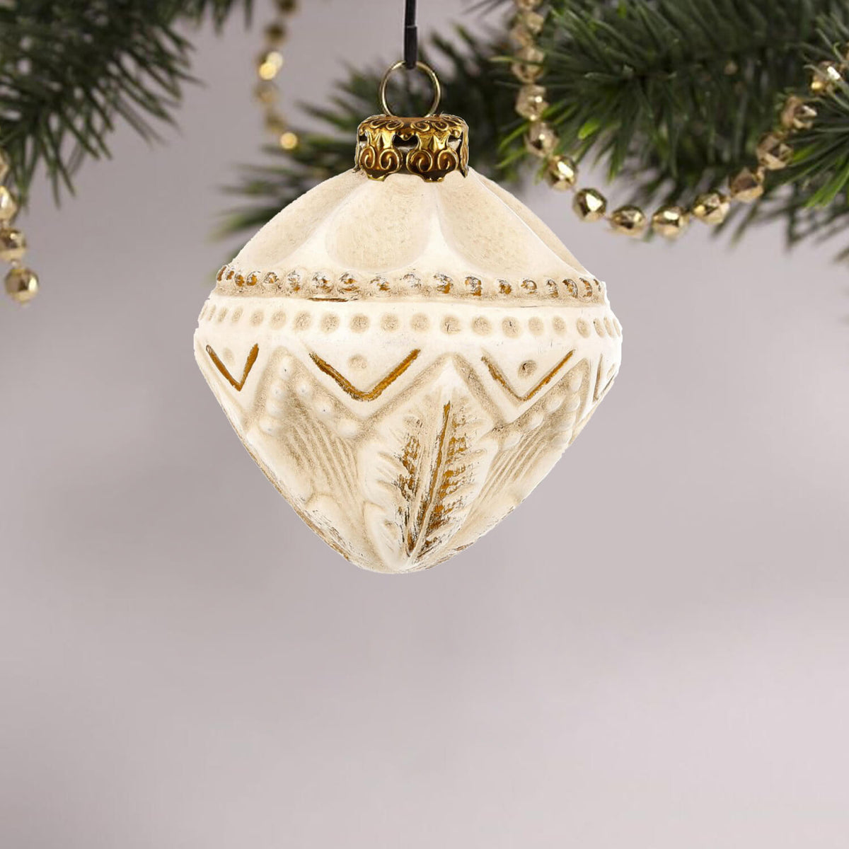Beautiful paper mache gyroscope ornament displayed on a Christmas tree, adding charm to holiday decorations.