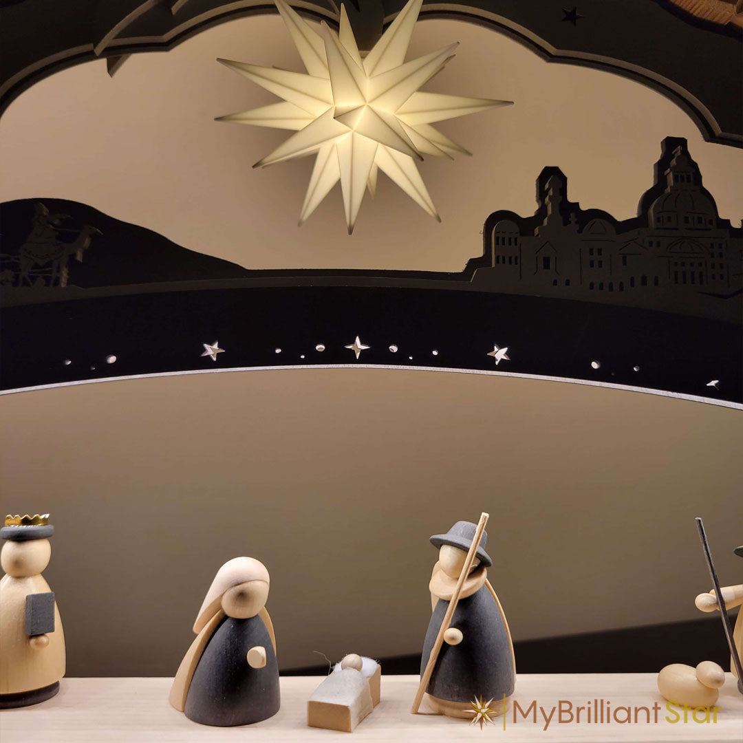 Nativity scene with star and silhouette of a town on a beige background