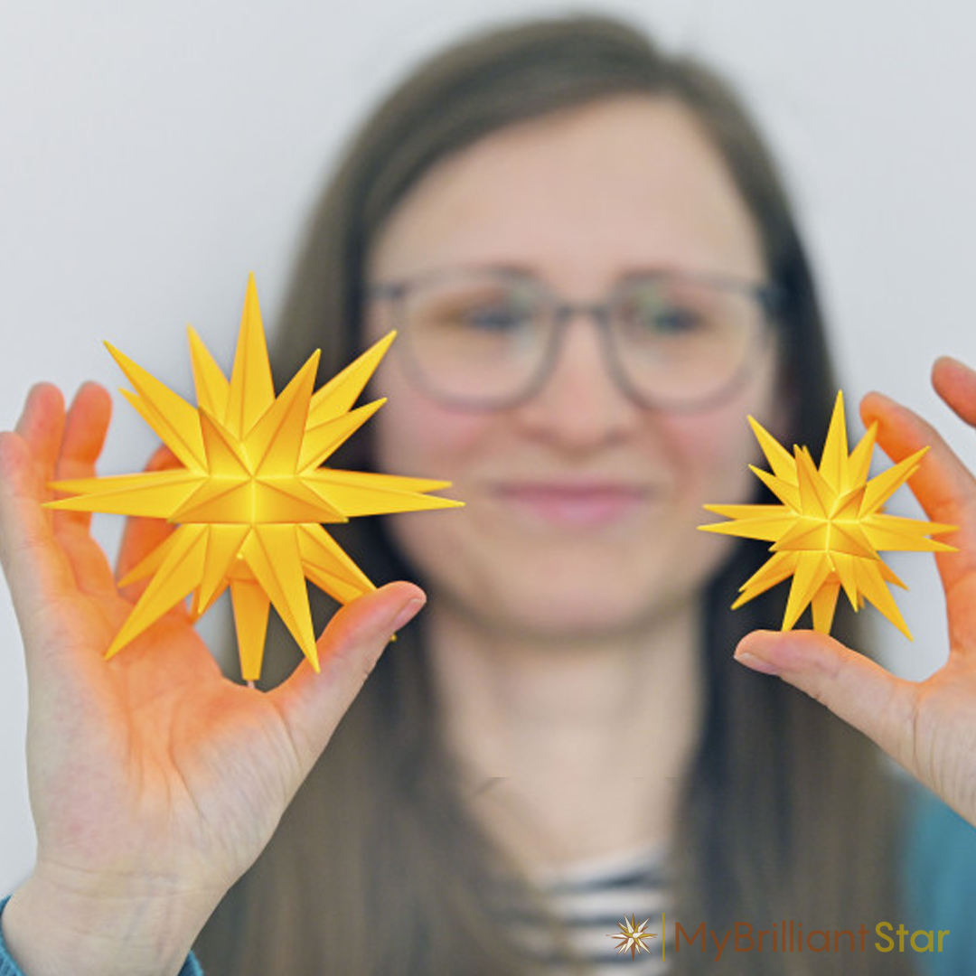 Woman is Holding two Original Herrnhut plastic MINISTAR, yellow, ~ 8 cm / 3 inch ø - LED