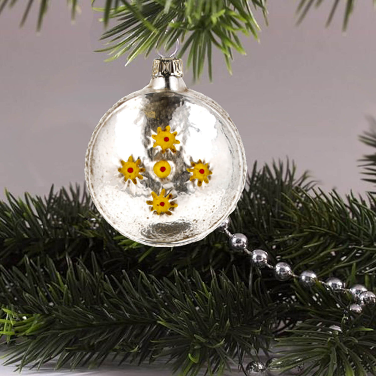 MAROLIN® - Glass ornament &quot;Ball with tree and stars&quot; displayed from the back hanging on a Christmas tree