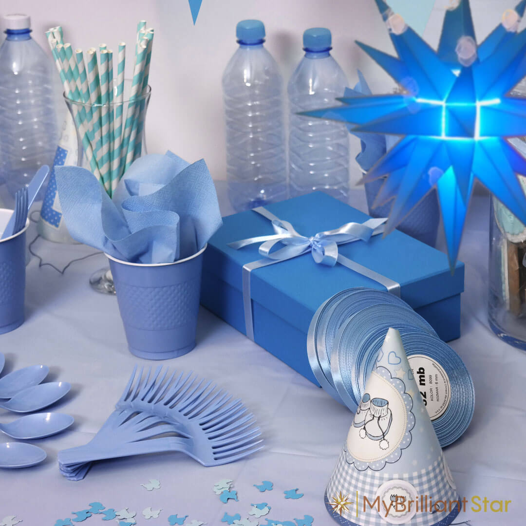 table with blue table cloth, blue forks, blue cups and a blue gift decorated with the blue Original Herrnhut plastic star, ~ 13 cm / 5 inch ø
