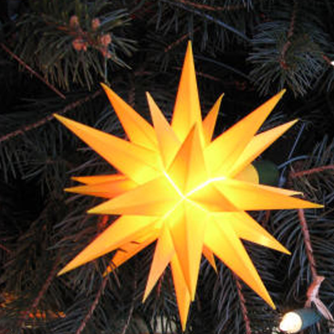 Yellow shining Herrnhut plastic star. yellow shining in Christmas tree