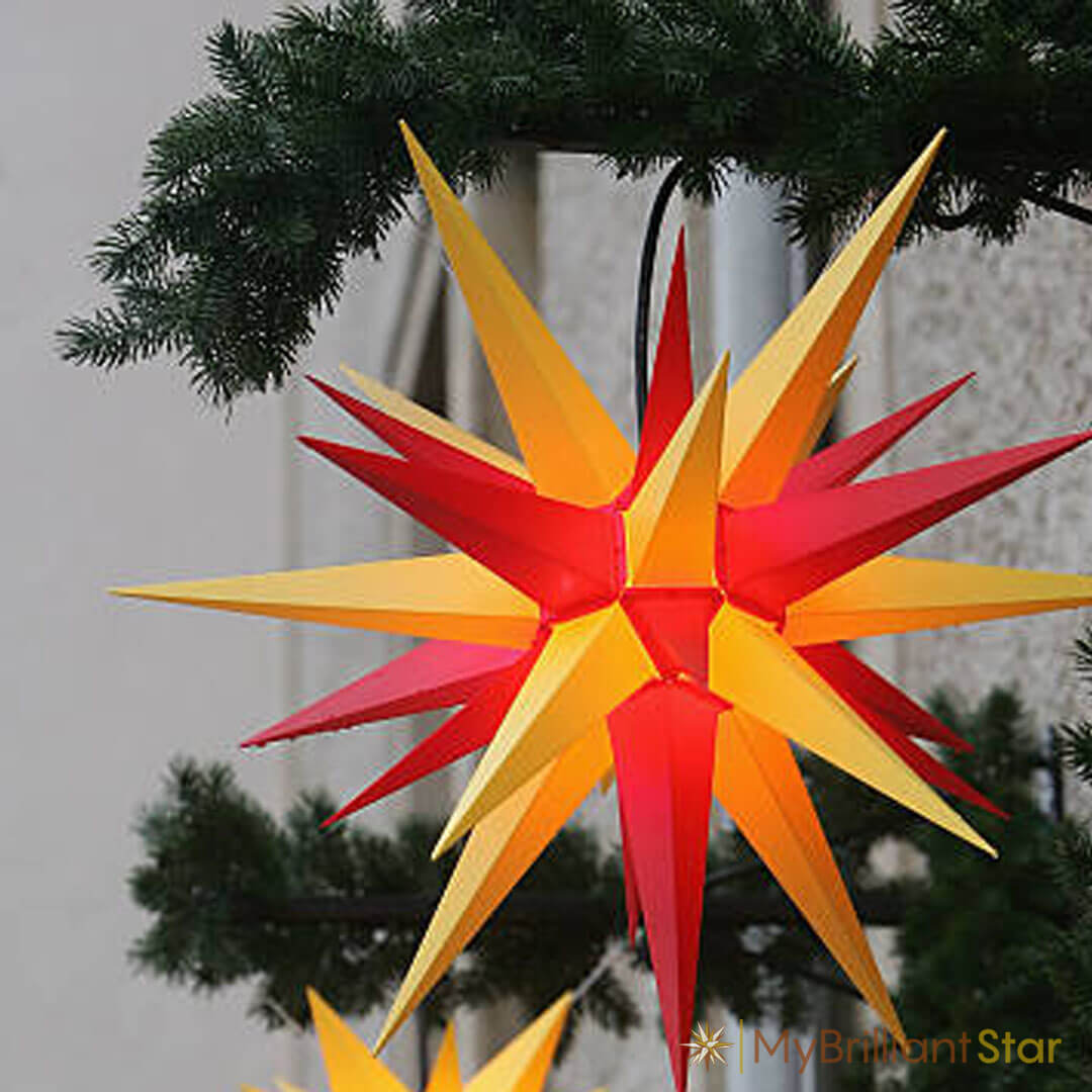 tree decorated with Original Herrnhut plastic star, yellow / red, ~ 70 cm / 27 inch ø