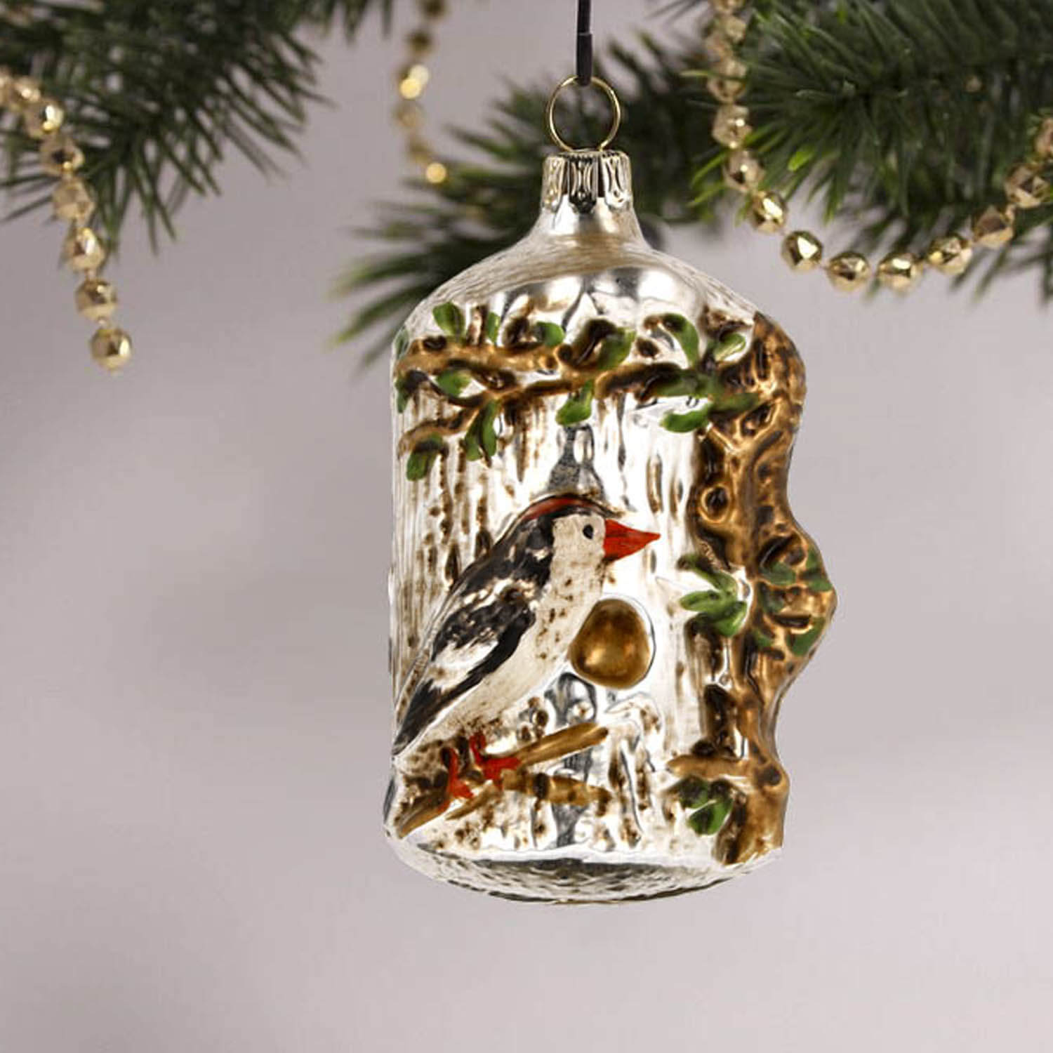 MAROLIN® - Glass ornament "Tree trunk with bird" displayed as decoration