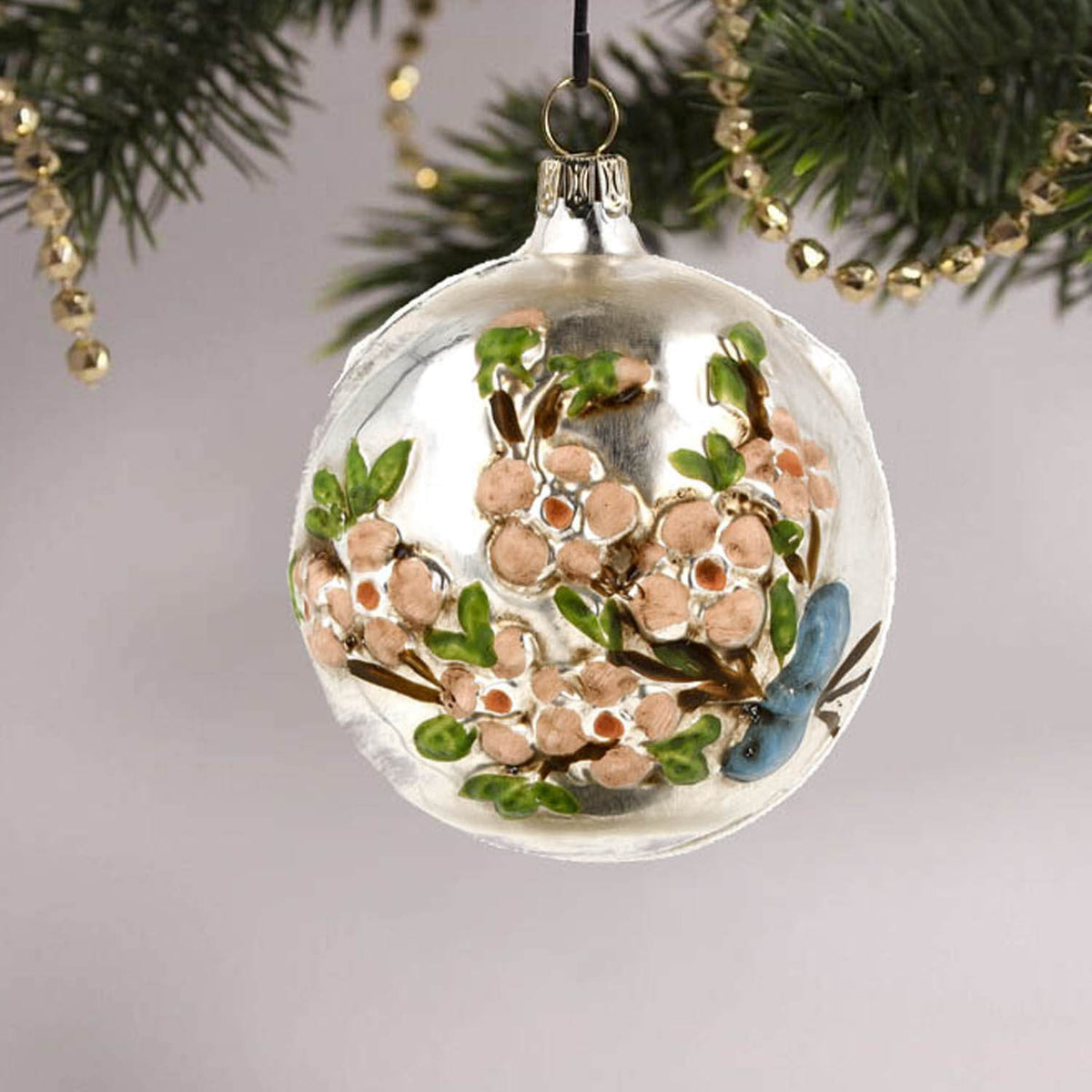MAROLIN® - Glass ornament &quot;Ball with flower branch with glitter&quot; hanging on a Christmas tree
