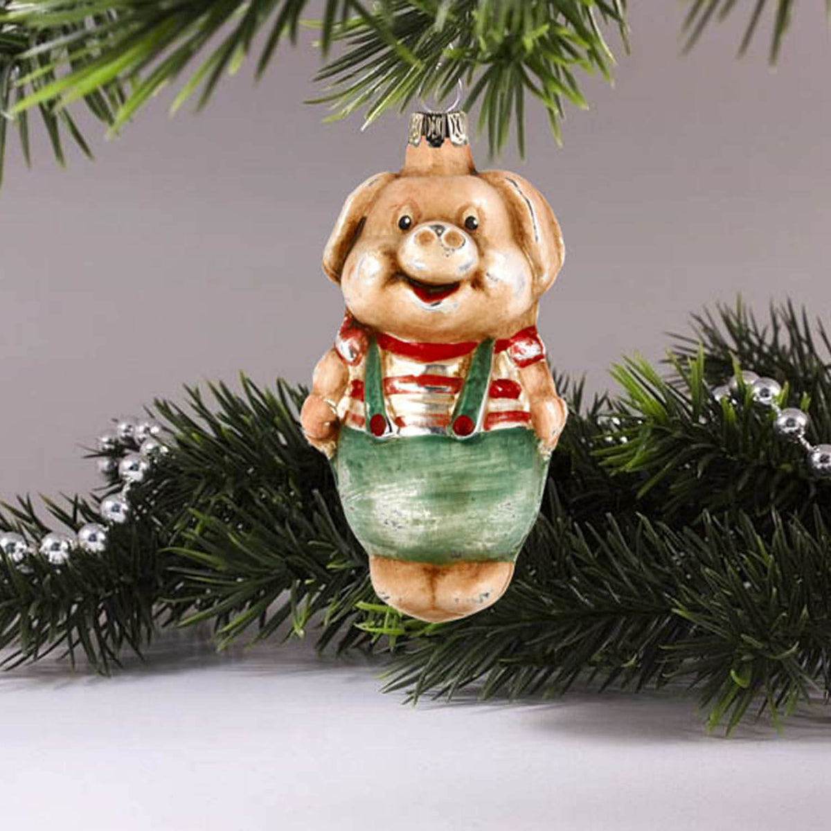 MAROLIN® - Glass ornament &quot;Pig with pants&quot; hanging on a tree