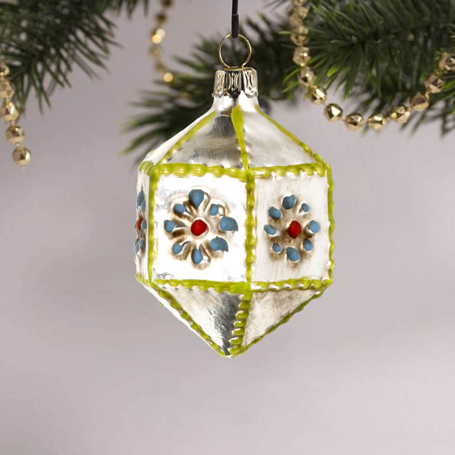 MAROLIN® - Miniature glass ornament "Hexagon with knobs blue" hanging on a decorated Christmas tree
