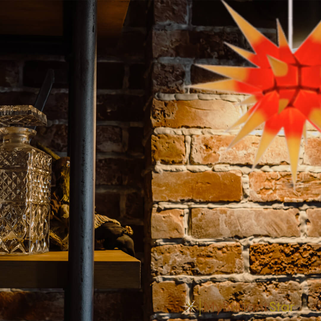 Original Herrnhut paper star, yellow / red center, ~ 60 cm / 24 inch ø hanging on a wall