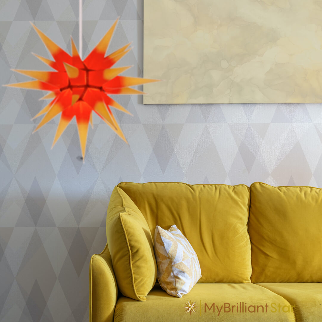 Original Herrnhut paper star, yellow / red center, ~ 70 cm / 27 inch ø above yellow sofa