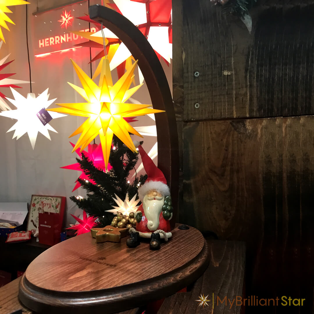 Walnut stained wooden Starbow with bright yellow plastic star and santa